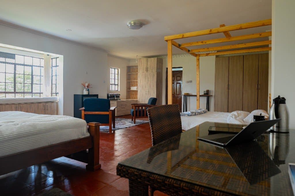 Nyati room at Wadich — open suite with seating area, canopy bed, and natural light