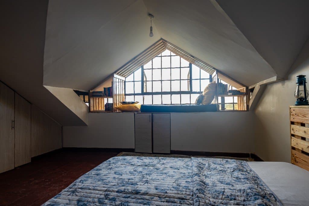 Twiga room at Wadich — attic suite with peaked ceiling, window seat, and built-in storage